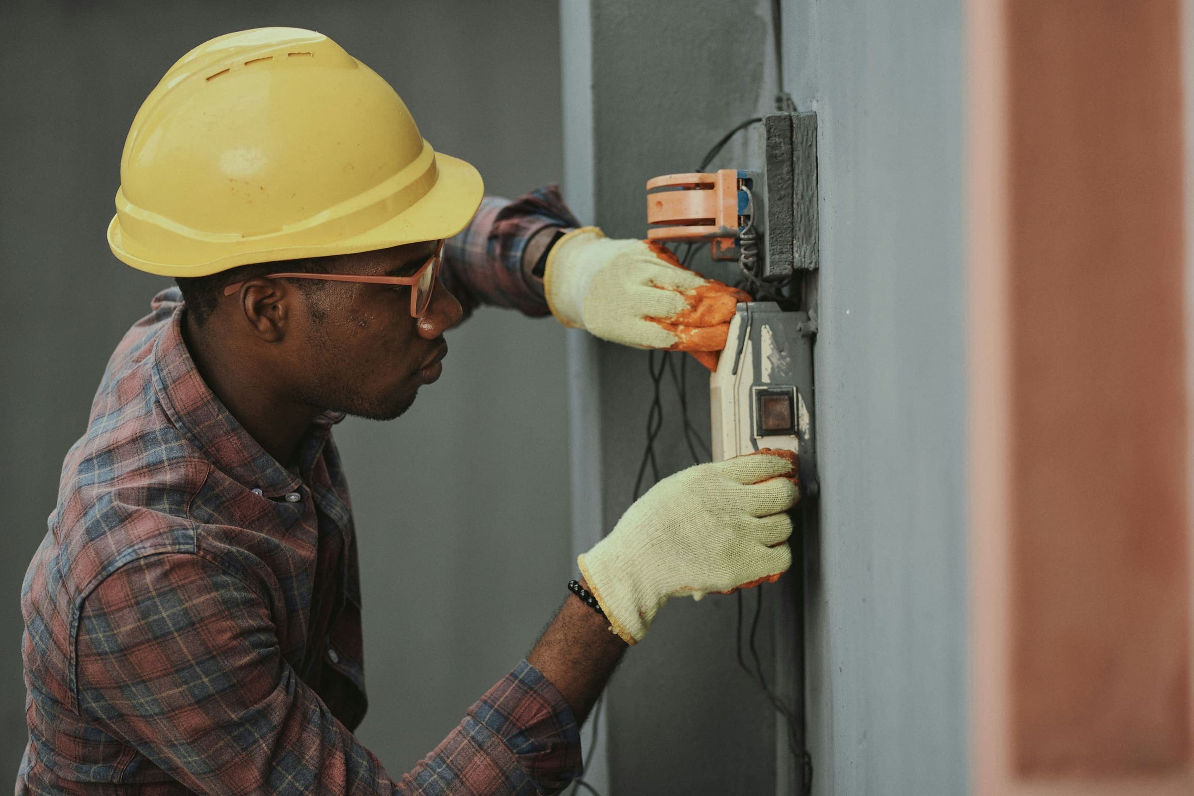 Electrician installing a wall electrical fitting on site